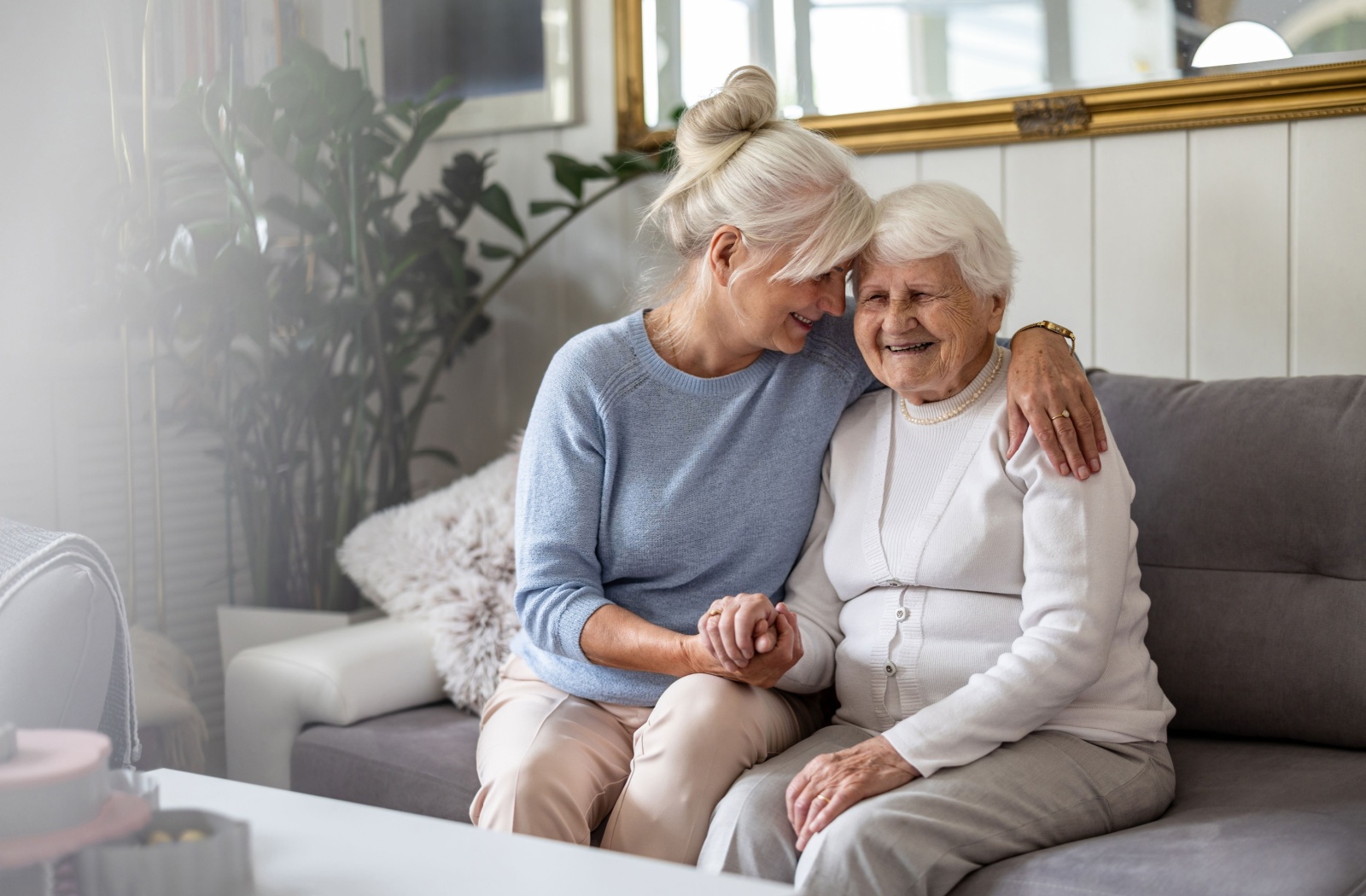 A memory care resident enjoys a hug from their adult child.