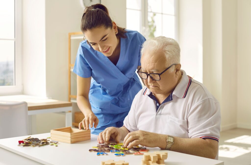 A memory care resident working on a specialized activity to help stimulate cognitive function with a staff member.